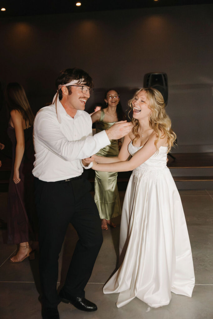 A bride a groom having the time of their lives at their wedding reception at Bespoke in Bond in Kentucky.