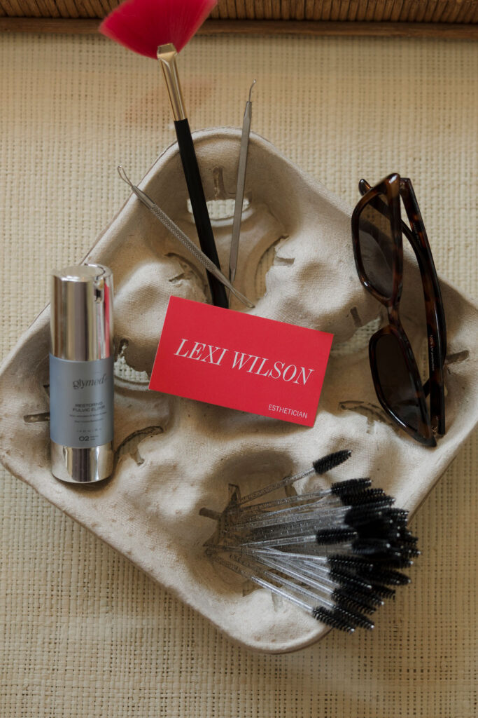 Louisville branding photographer | a drink carrier with sunglasses, mascara wands, a pair of sunglasses, product and a business card laying in it.
