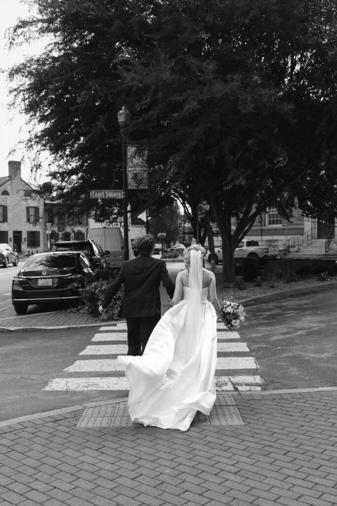 Bride and groom walking through downtown Bardstown Kentucky on their wedding day.