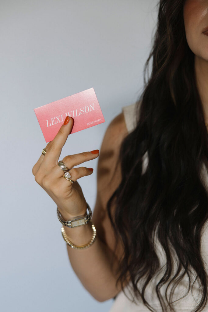 Louisville branding photographer | an esthetician holding her hot pink business card.