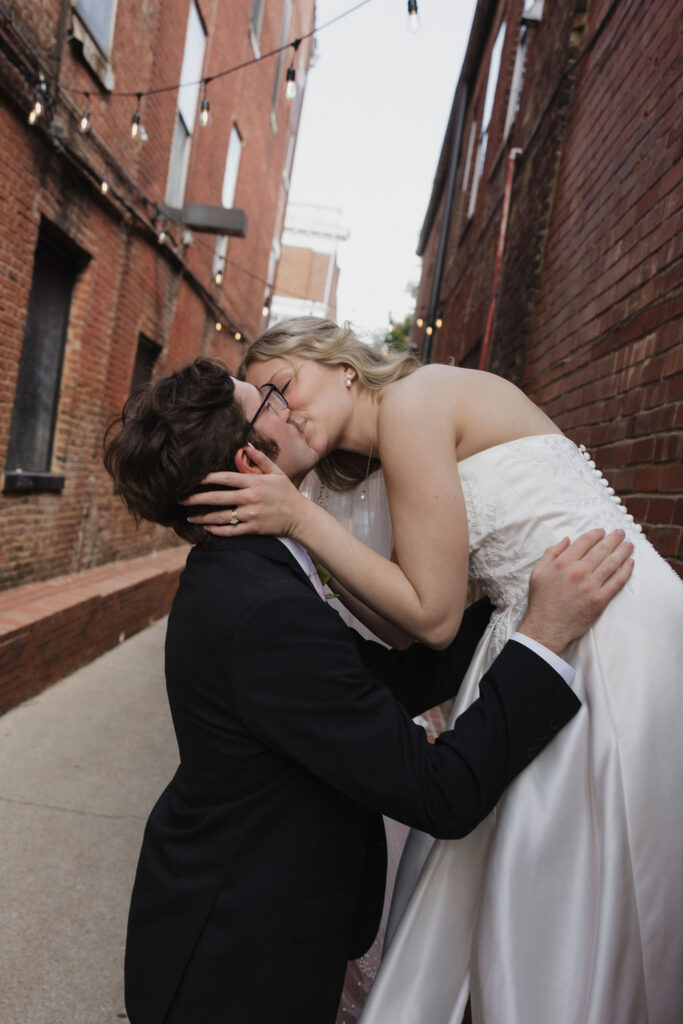 A romantic kiss between a bride and groom in a beautiful alley way in downtown Bardstown, Kentucky.