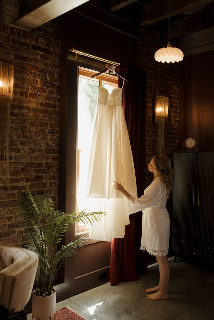A portrait of a bride admiring her wedding dress at Bespoke in Bond in Bardstown, Kentucky.