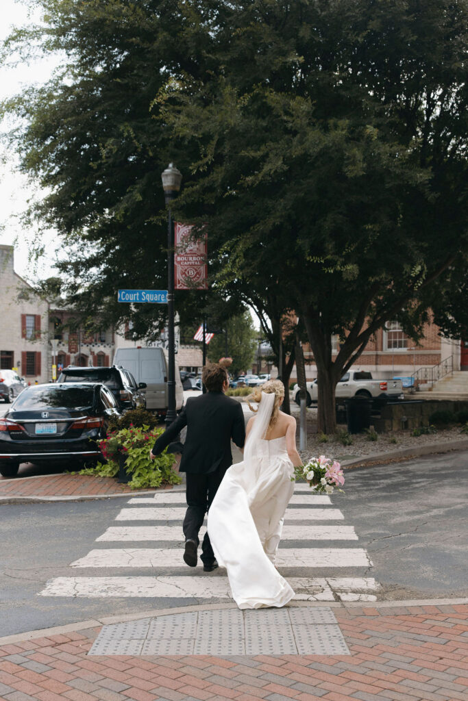 Couple running during their Bespoke in Bond wedding in Bardstown Kentucky.