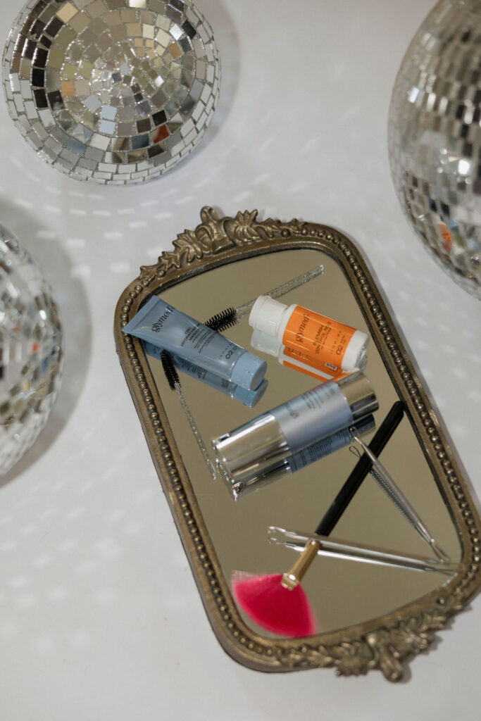 Louisville branding photographer | Some facial products and extraction tools laying on a mirror as a flat lay.
