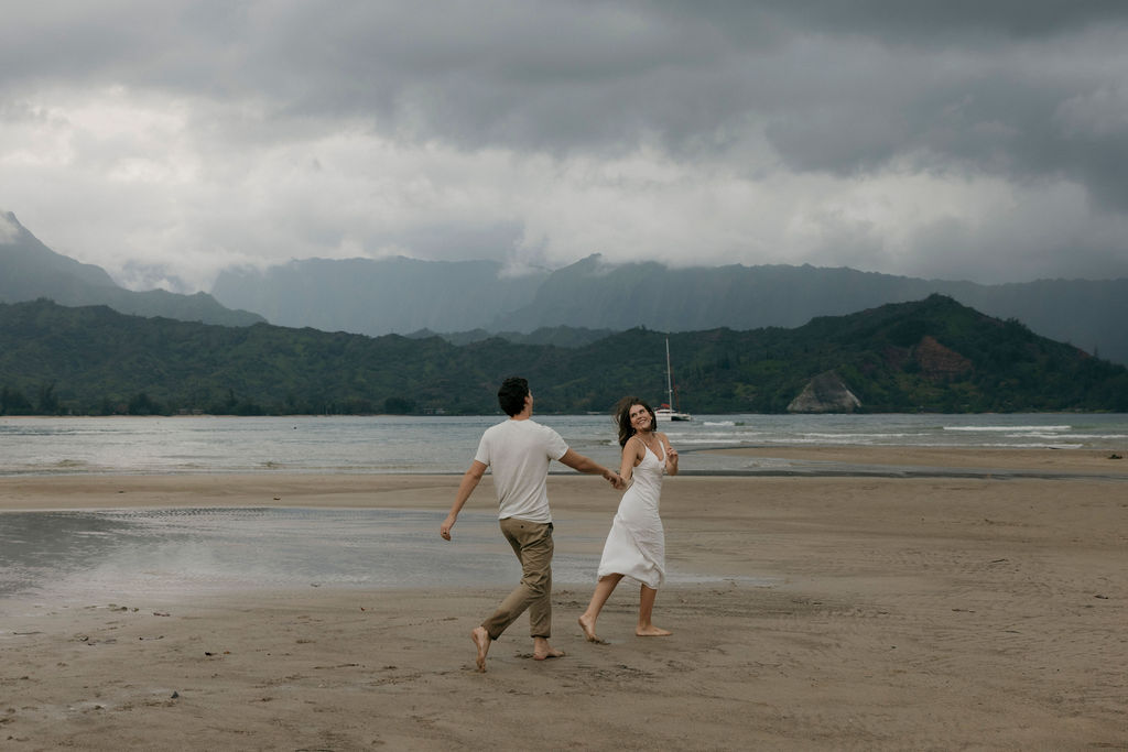 Couple laughing as they walk through the water on Hanalei Beach