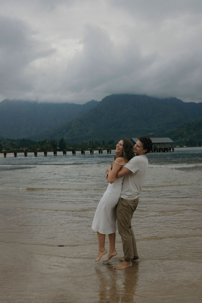 Couple laughing together during a rainy engagement session in Kauai, Hawaii