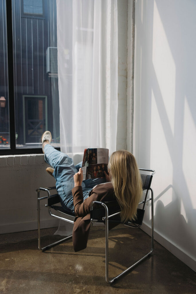 Hairstylist relaxing in a modern chair during her studio branding session.