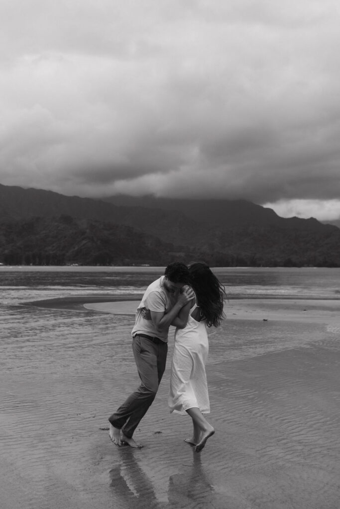 Joyful engagement portrait captured beside the ocean in Kauai