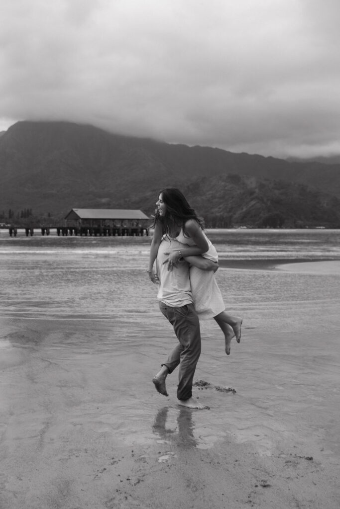 Couple smiling together during a fun beach engagement session in Hawaii
