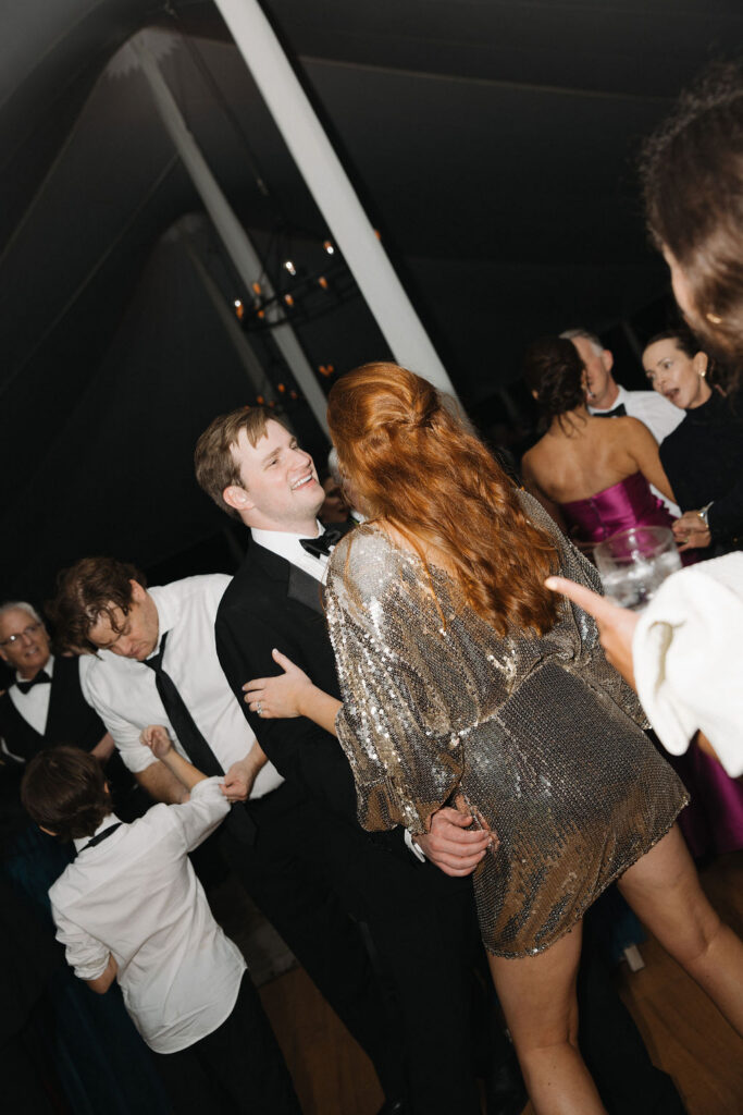 Bride and groom celebrating on the dance floor in a sparkling reception dress