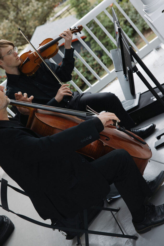 Two string musicians playing as the processional begins.