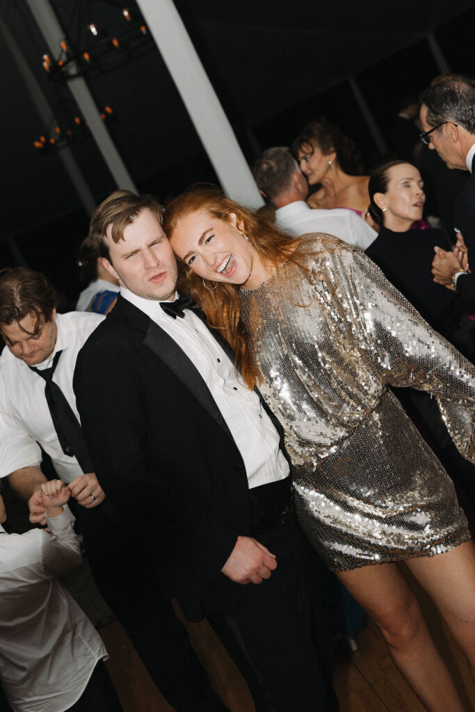 The bride and groom enjoying their reception in her sparkling reception dress.