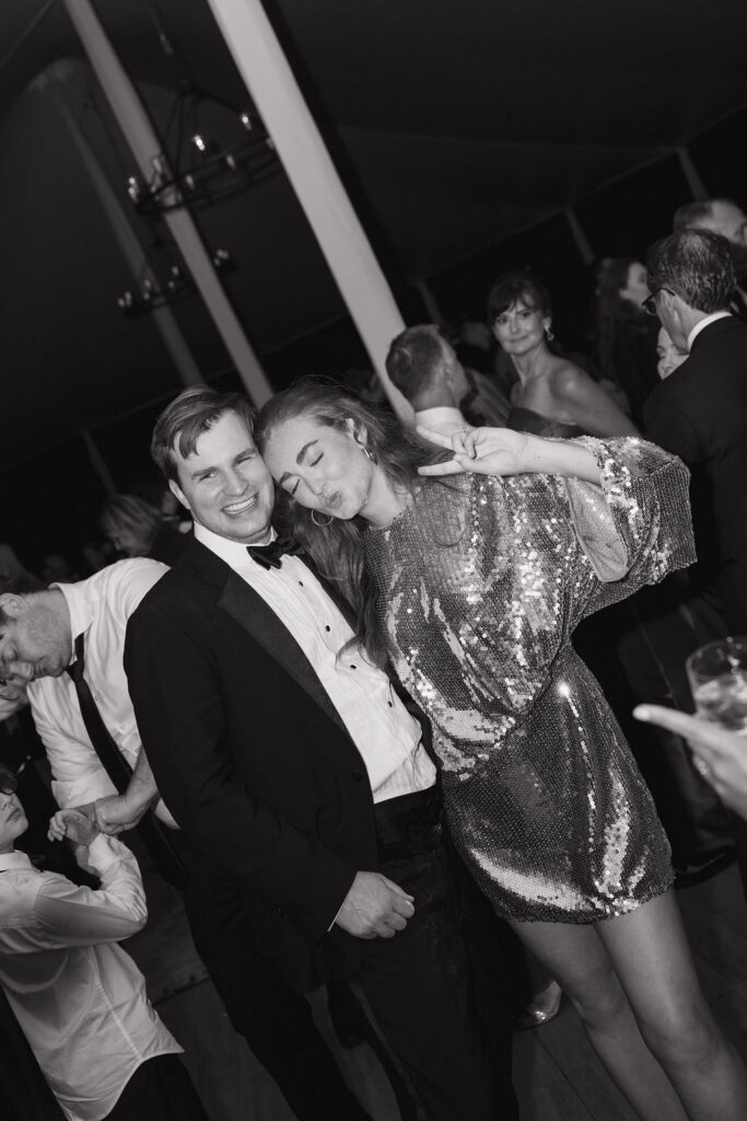 Black and white photo of the bride and groom posing for the photo on the dance floor.